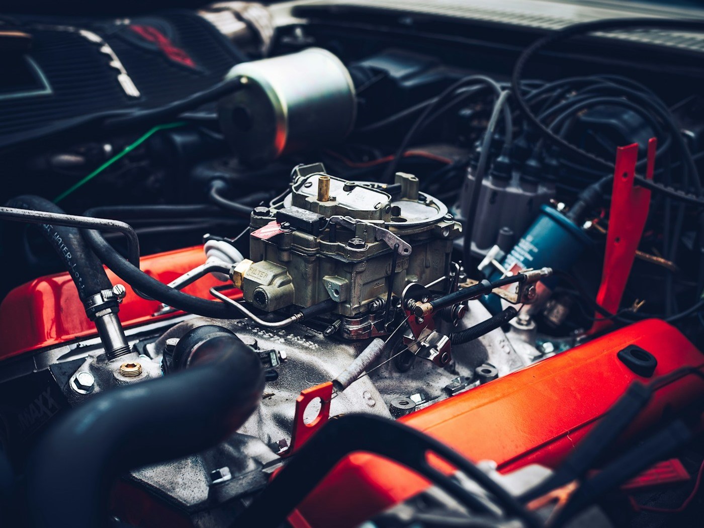 An engine bay with the hood open in a repair shop