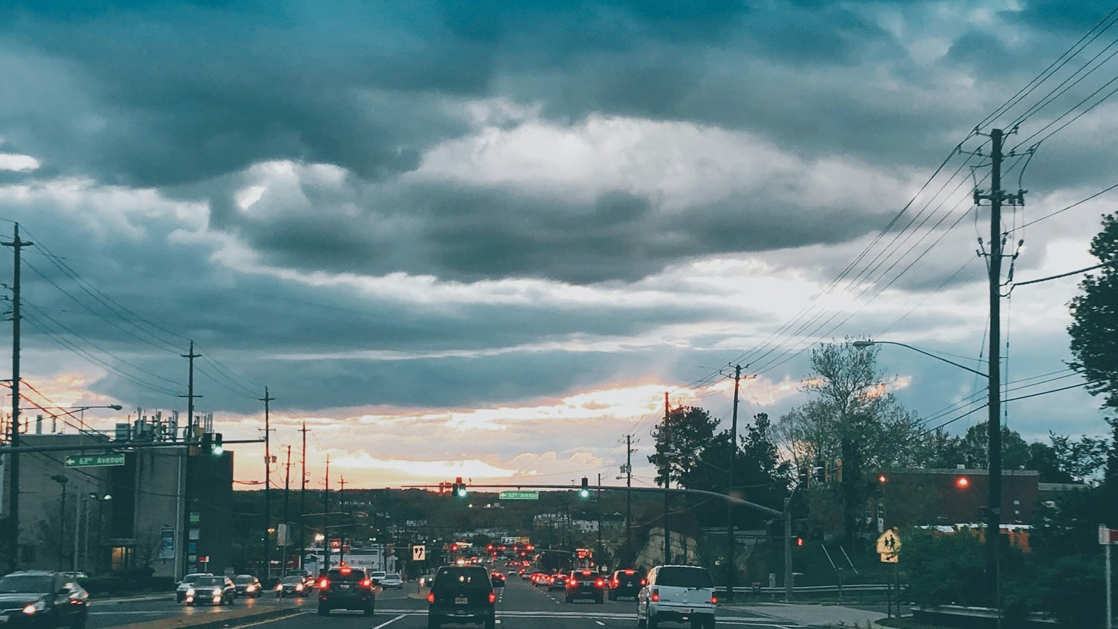 Traffic on a suburban highway under a dramatic evening sky