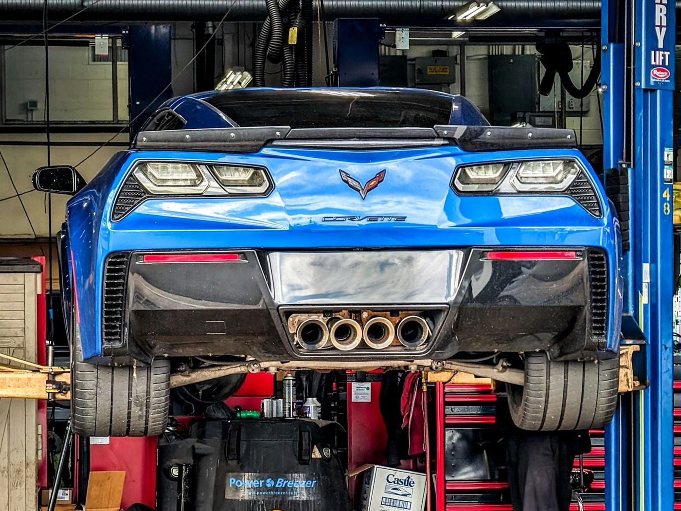 A car raised on a lift in a service bay