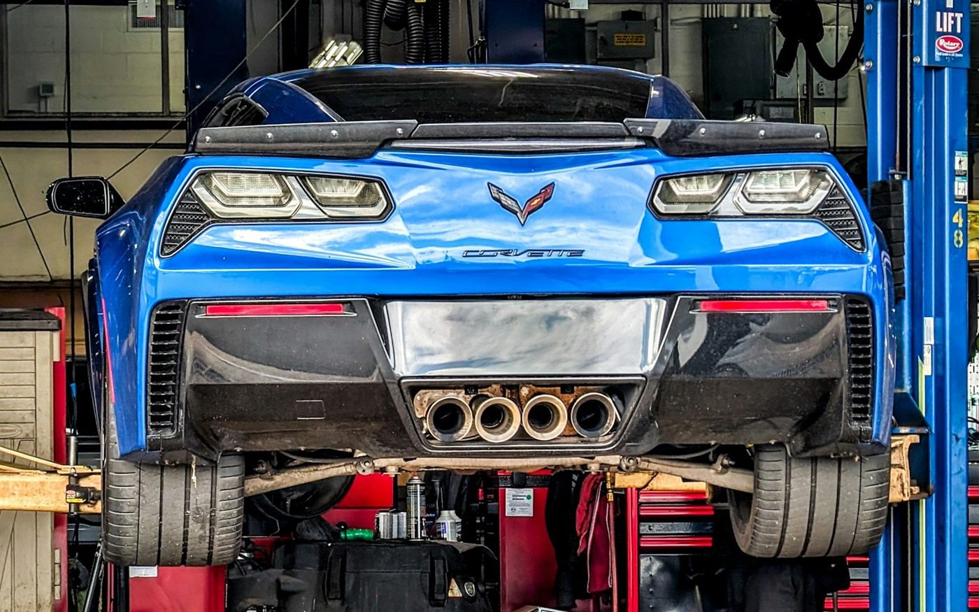 A car raised on a lift in a service bay