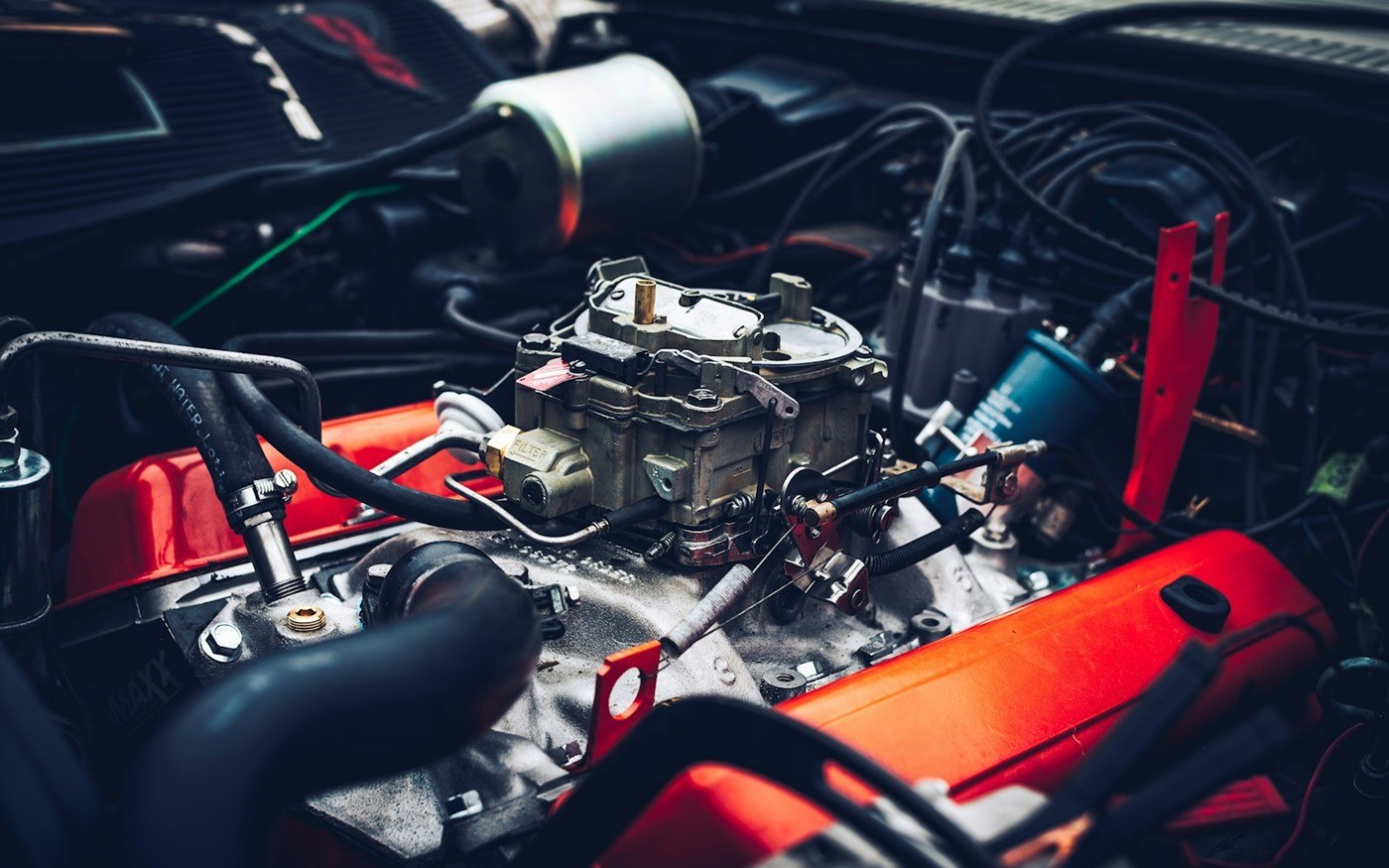 An engine bay with the hood open in a repair shop